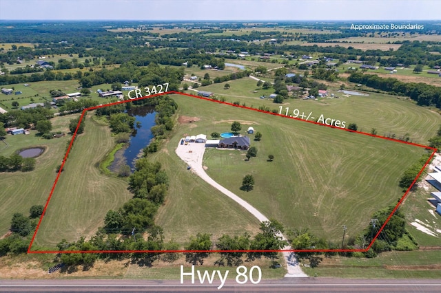 birds eye view of property featuring a water view and a rural view