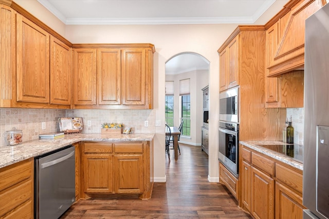 kitchen with tasteful backsplash, stainless steel appliances, light stone counters, crown molding, and dark hardwood / wood-style flooring