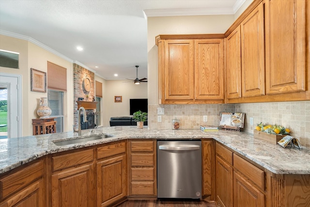 kitchen featuring kitchen peninsula, light stone countertops, sink, and ornamental molding