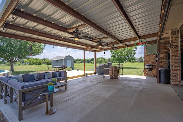 view of patio / terrace with an outdoor hangout area, ceiling fan, and a storage shed