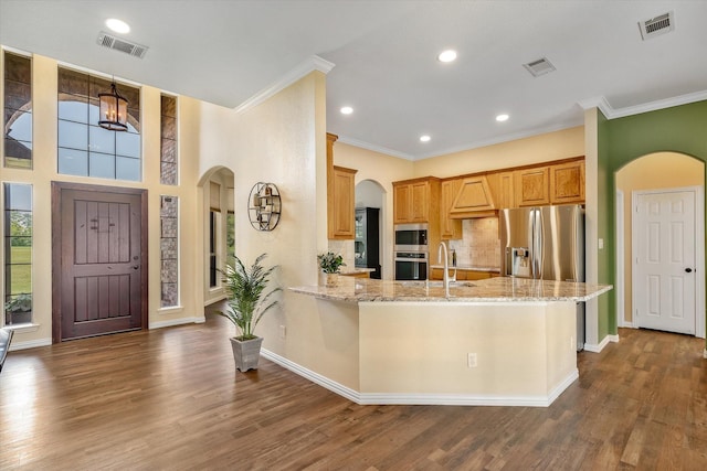 kitchen featuring light stone counters, ornamental molding, stainless steel appliances, and dark wood-type flooring