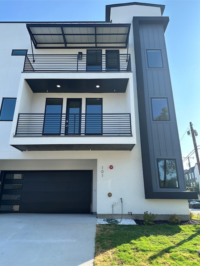 view of front facade featuring a balcony, a garage, and a front lawn