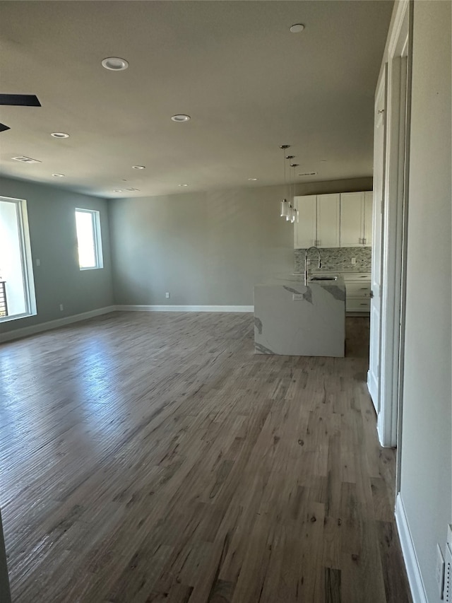 unfurnished living room with light hardwood / wood-style flooring and sink