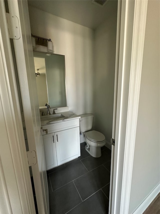 bathroom with vanity, toilet, and tile patterned floors