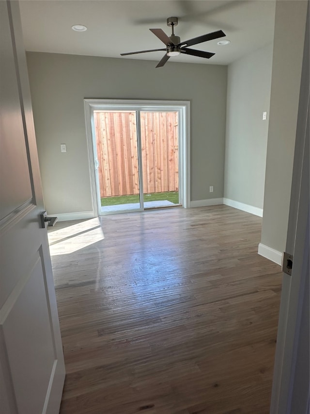 unfurnished room with dark hardwood / wood-style flooring and ceiling fan