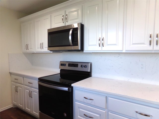 kitchen with appliances with stainless steel finishes, light stone countertops, decorative backsplash, and white cabinets