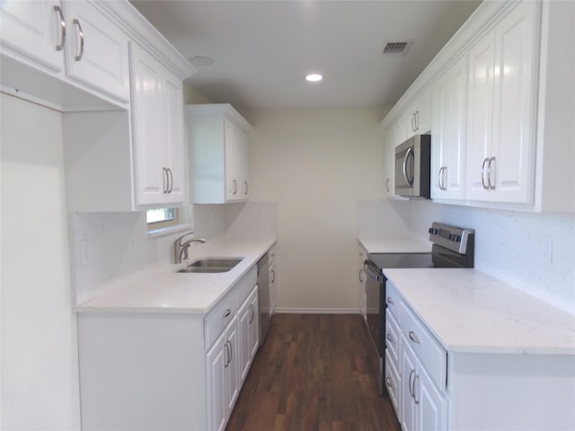 kitchen featuring sink, stainless steel appliances, tasteful backsplash, white cabinets, and dark hardwood / wood-style flooring