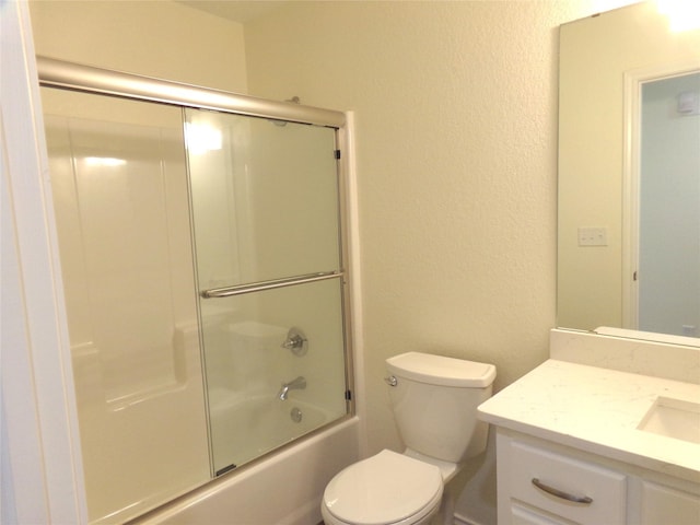 full bathroom featuring vanity, shower / bath combination with glass door, and toilet