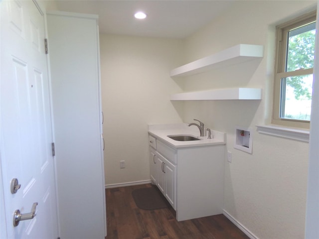 clothes washing area featuring cabinets, washer hookup, dark hardwood / wood-style floors, and sink