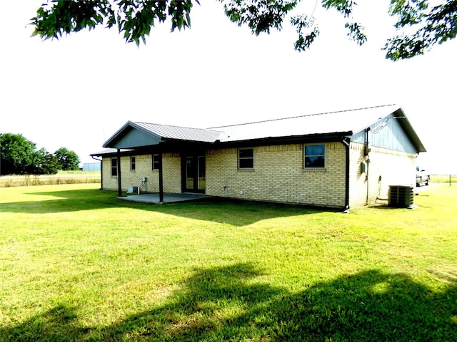 back of property featuring a yard, a patio area, and central air condition unit