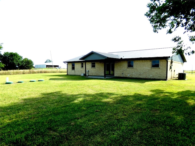 back of house with a yard and central air condition unit