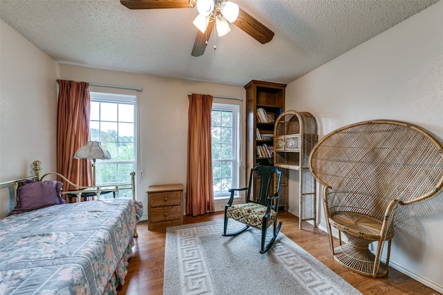 bedroom featuring a textured ceiling, wood-type flooring, and ceiling fan