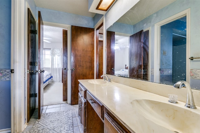 bathroom featuring ceiling fan, tile patterned floors, a textured ceiling, and vanity