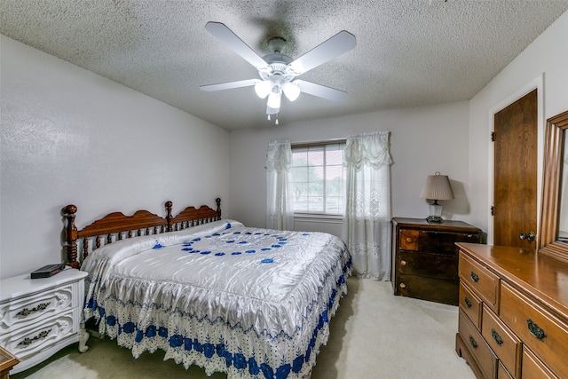 carpeted bedroom featuring a textured ceiling and ceiling fan