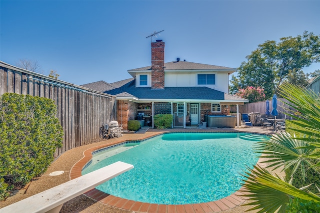 view of swimming pool with a patio and a diving board