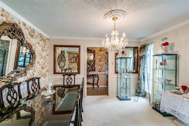 carpeted dining area with a chandelier, a textured ceiling, and crown molding