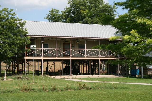 back of property featuring ceiling fan and a lawn