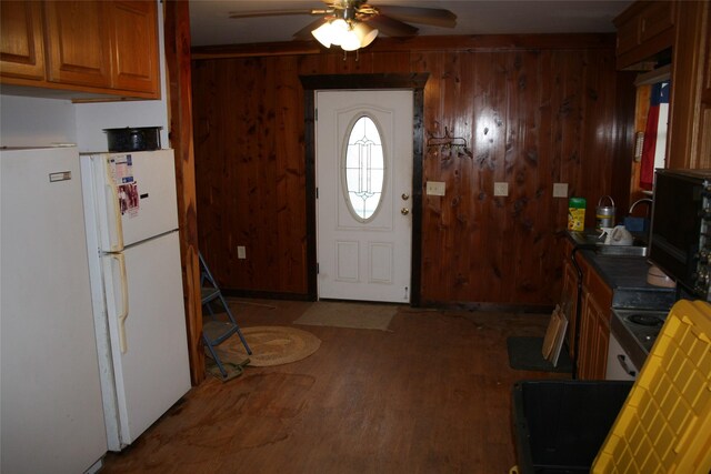 entryway featuring wood-type flooring, wooden walls, and ceiling fan