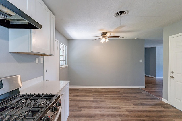 kitchen with white cabinets, dark hardwood / wood-style flooring, range hood, and stainless steel range with gas stovetop