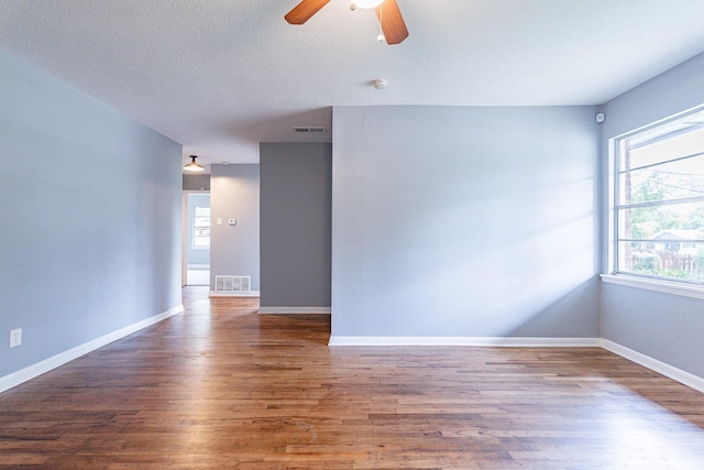 empty room featuring ceiling fan, dark hardwood / wood-style flooring, and a textured ceiling