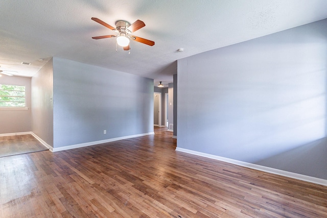 spare room with ceiling fan, dark hardwood / wood-style flooring, and a textured ceiling