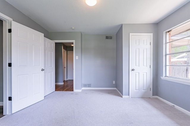 unfurnished bedroom featuring carpet floors and multiple windows