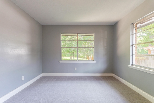 carpeted spare room featuring plenty of natural light