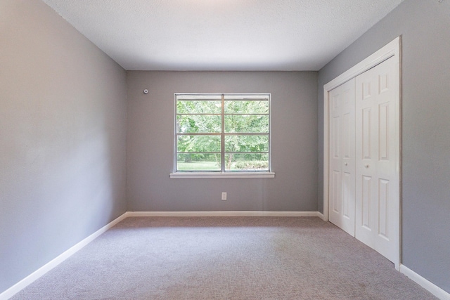 unfurnished bedroom with a closet, carpet floors, and a textured ceiling