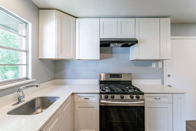 kitchen with white cabinetry, sink, and gas range