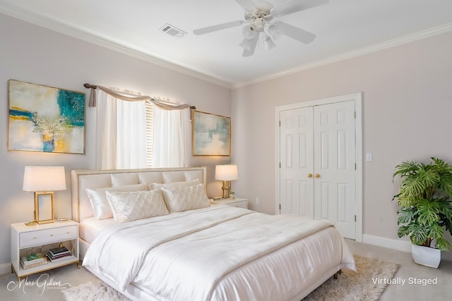 carpeted bedroom with ceiling fan, ornamental molding, and a closet