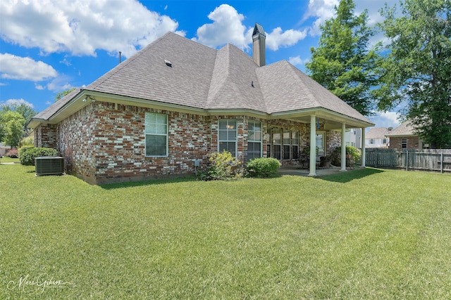 rear view of property with a patio area, central AC unit, and a lawn