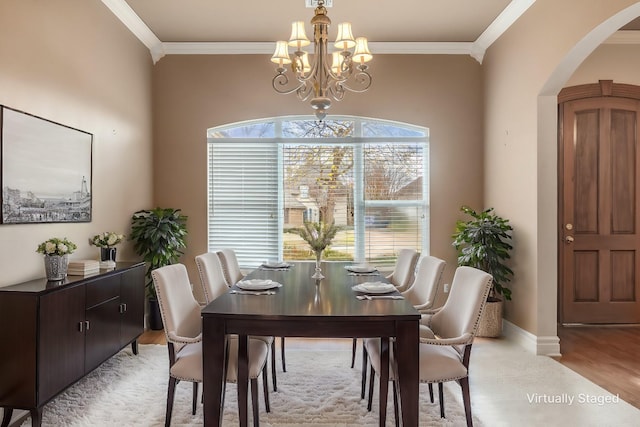 dining area featuring a notable chandelier, ornamental molding, and light hardwood / wood-style floors