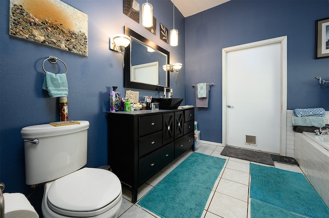 bathroom with tile patterned floors, toilet, vanity, and tiled tub