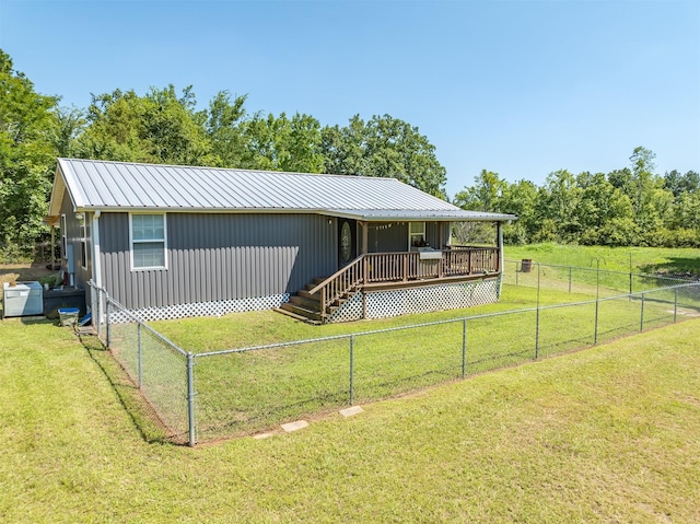 view of front of house with a wooden deck and a front lawn