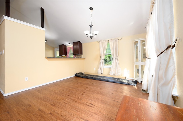 unfurnished living room featuring a chandelier and light hardwood / wood-style flooring