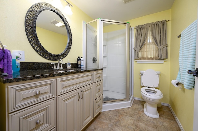 bathroom with walk in shower, vanity, and toilet