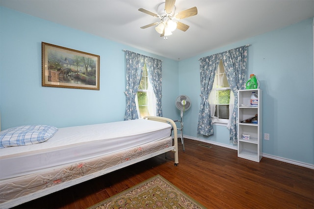 bedroom with multiple windows, dark wood-type flooring, and ceiling fan