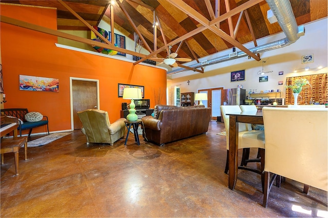 living room with concrete flooring and high vaulted ceiling