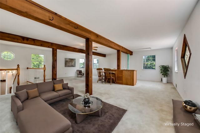 living room with beam ceiling, light colored carpet, and a healthy amount of sunlight