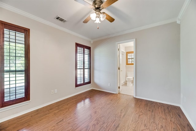 empty room with crown molding, plenty of natural light, ceiling fan, and light hardwood / wood-style flooring