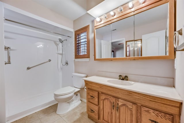 bathroom featuring vanity, toilet, tile patterned flooring, and walk in shower