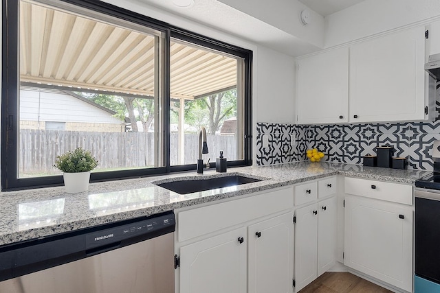 kitchen with white cabinets, appliances with stainless steel finishes, tasteful backsplash, and sink