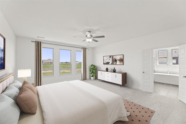 bedroom featuring ensuite bath, ceiling fan, visible vents, and carpet flooring