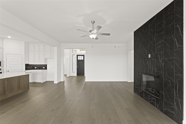 living room with a premium fireplace, ceiling fan, and dark hardwood / wood-style floors