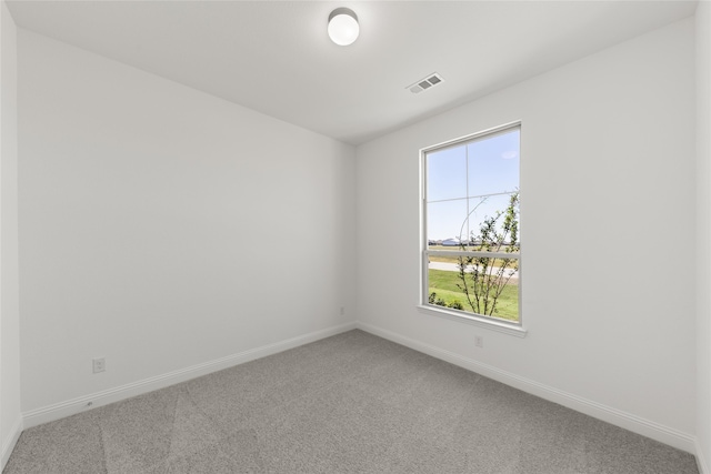 carpeted empty room featuring visible vents and baseboards