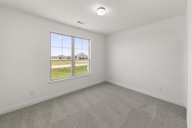 carpeted empty room featuring baseboards and visible vents