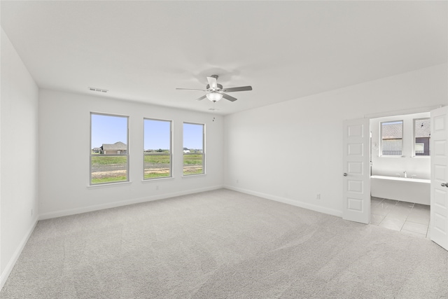 spare room with light colored carpet and ceiling fan