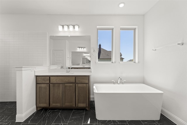 bathroom with tile walls, a bathtub, and vanity