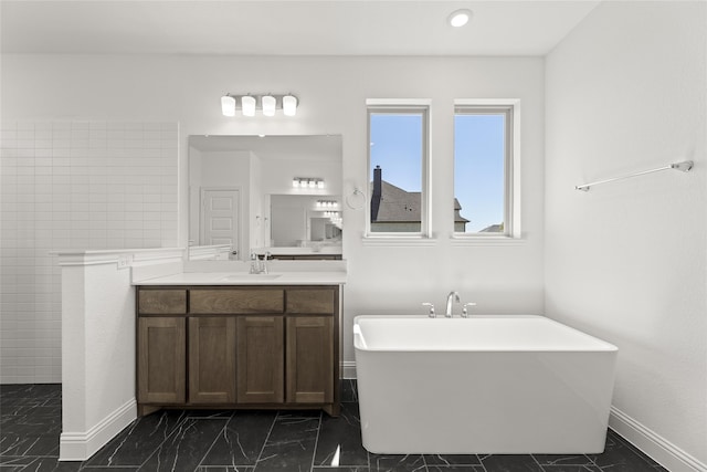 full bathroom with baseboards, a soaking tub, marble finish floor, vanity, and a walk in shower