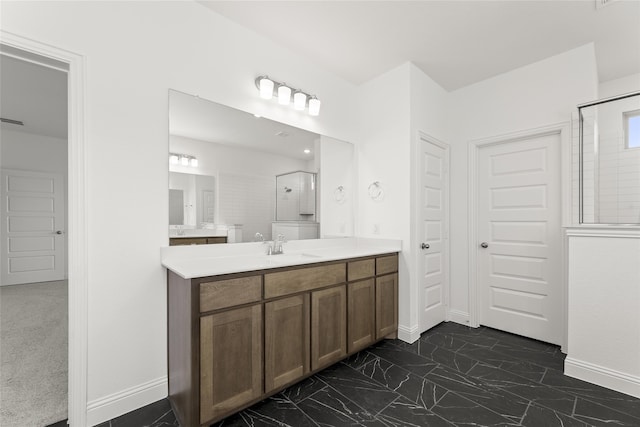 bathroom featuring marble finish floor, a shower with door, vanity, and baseboards